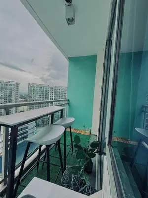 a balcony with two chairs and a table and a plant at Azure staycation By Icay in Manila