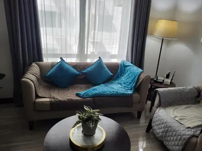 a living room with a couch with blue pillows at Lancaster Hotel Manila Executive Suite Room 1001 in Manila