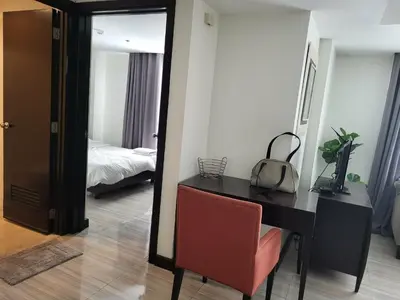 a room with a desk and a mirror and a bed at Lancaster Hotel Manila Executive Suite Room 1001 in Manila