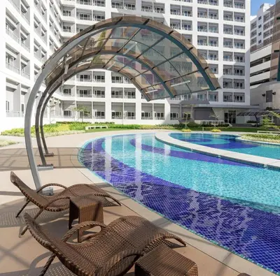 a swimming pool in front of a building at John's place near BGC and Airport in Manila