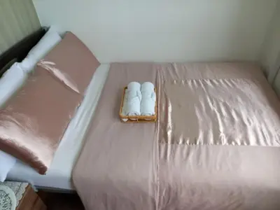 a bed with two slippers on top of it at John's place near BGC and Airport in Manila