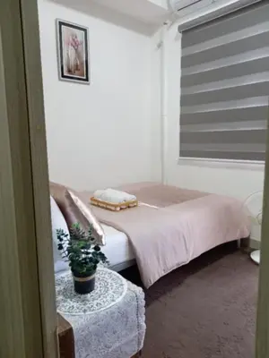 a bedroom with a bed and a table with a plant at John's place near BGC and Airport in Manila