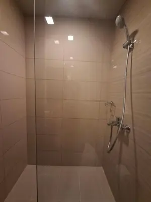 a bathroom with a shower with a glass door at Mysuites2go24K Parksuites T2 in Manila