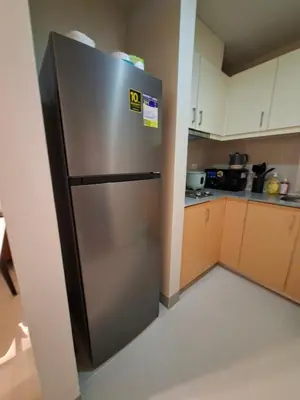 a stainless steel refrigerator in a small kitchen at Mysuites2go24K Parksuites T2 in Manila