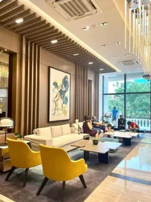 a living room with yellow chairs and couches and people at Mysuites2go24K Parksuites T2 in Manila