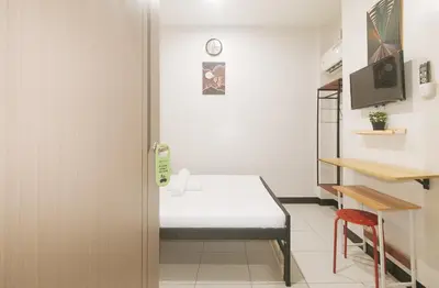 a small room with a bed and a table at UrbanView at Mherylle's Apartment near UST Manila in Manila