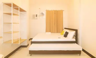 a small room with two beds and shelves at UrbanView at Mherylle's Apartment near UST Manila in Manila
