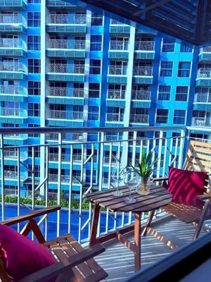 a balcony with a table and chairs and a building at 2BR at Bayshore 2 Near Okada & Airport in Manila