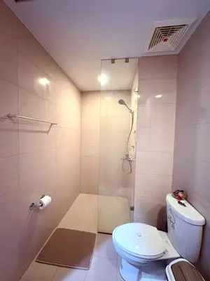 a white bathroom with a shower and a toilet at 2BR at Bayshore 2 Near Okada & Airport in Manila