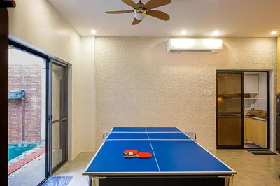 a ping pong table in a room with a ceiling fan at Ephram House - A-Frame Cabin Staycation with Pool, Games & BBQ For Up To 20 Guests in Bacoor