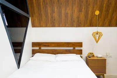 a bedroom with a white bed and a wooden headboard at Ephram House - A-Frame Cabin Staycation with Pool, Games & BBQ For Up To 20 Guests in Bacoor