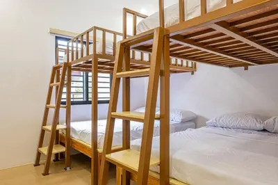 a room with two bunk beds and a bed at Ephram House - A-Frame Cabin Staycation with Pool, Games & BBQ For Up To 20 Guests in Bacoor