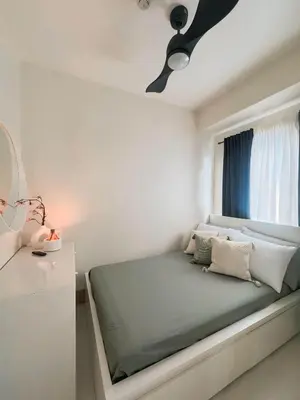 a bed in a white room with a window at Summer At The Shore in Manila