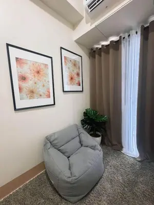 a living room with a chair and a window at Summer At The Shore in Manila