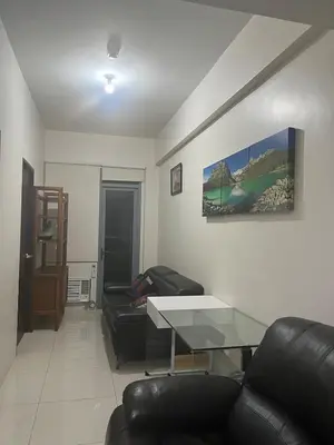 a living room with two couches and a glass table at 1 BR Unit at Park West - BGC in Manila