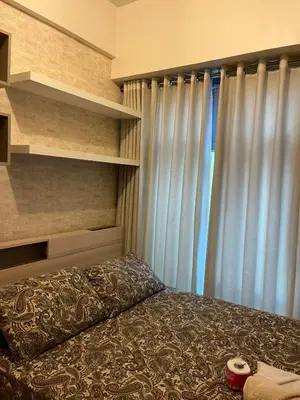 a bedroom with a bed and a window at 1 BR Unit at Park West - BGC in Manila