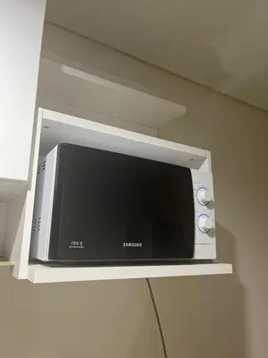 a microwave sitting on a shelf in a kitchen at 1 BR Unit at Park West - BGC in Manila