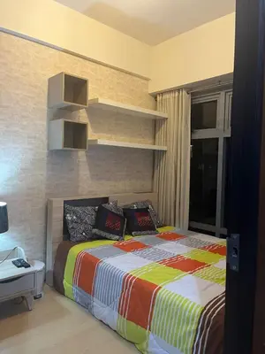a bedroom with a bed with a colorful blanket at 1 BR Unit at Park West - BGC in Manila
