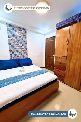 a bedroom with a bed and a wooden cabinet at Suite Haven Staycation in Sampong