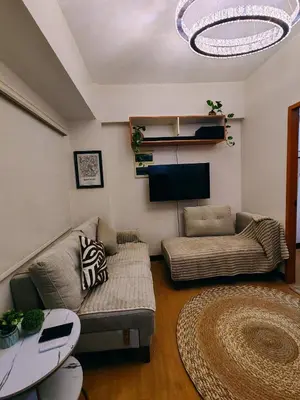 a living room with a couch and a tv at Charming 2BR Condo in Cambridge with WIFI, Smart TV in Cainta