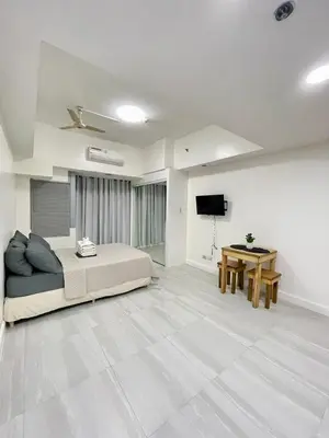 a large bedroom with a bed and a table at Charming condo unit Across US Embassy in Manila