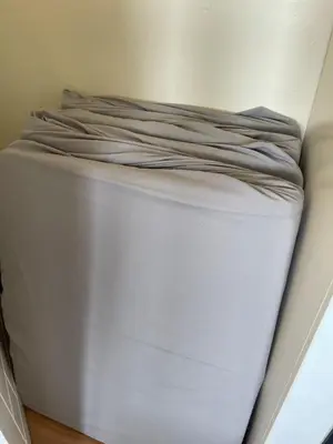 a white bed in a corner of a room at Charming condo unit Across US Embassy in Manila