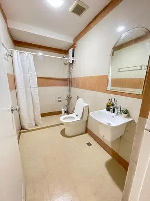 a bathroom with a toilet and a sink and a mirror at Charming condo unit Across US Embassy in Manila