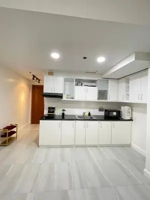 a large white kitchen with white cabinets and a floor at Charming condo unit Across US Embassy in Manila