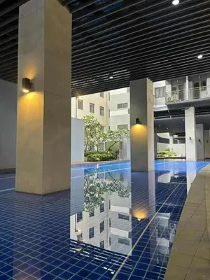 a lobby with a reflection of a building in a pool at Mystix's Pad in Manila