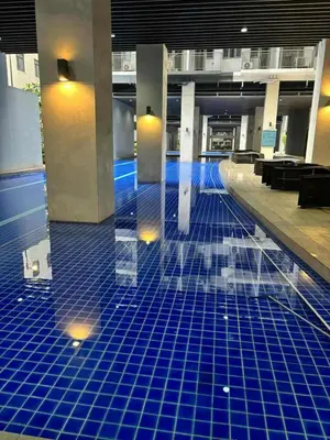 a pool in a building with blue tiles on the floor at Mystix's Pad in Manila