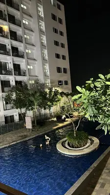 a group of people swimming in a swimming pool at night at Shore 2 Residences - The Grand Haven II in Manila