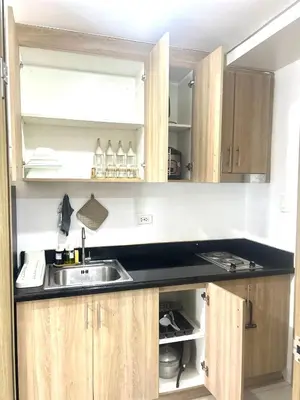 a kitchen with a sink and wooden cabinets at Shore 2 Residences - The Grand Haven II in Manila