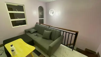 a living room with a couch and a table at Silang Guest house