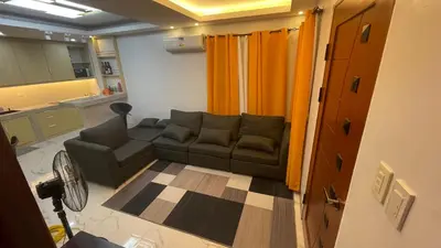a living room with a couch and a kitchen at Silang Guest house