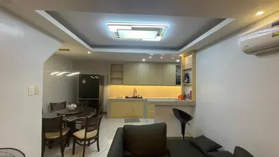 a living room and kitchen with a table and chairs at Silang Guest house