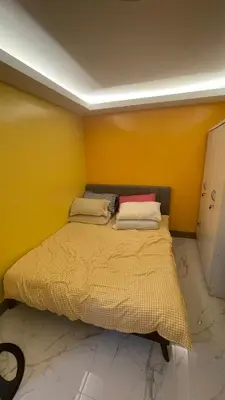 a bed in a room with a yellow wall at Silang Guest house