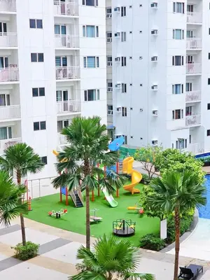 a playground in front of a building with palm trees at Grand Line Hideout in Manila
