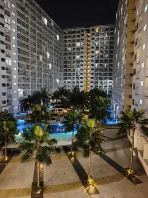 a view of a city at night with palm trees at Grand Line Hideout in Manila