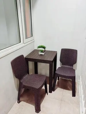 two chairs and a table and a table with a plant at Grand Line Hideout in Manila