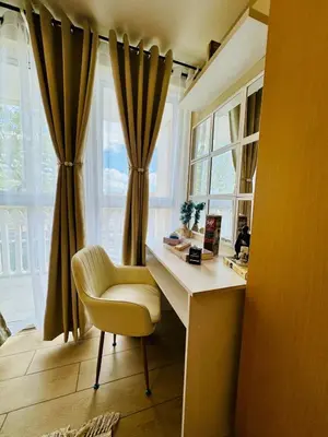 a desk with a chair in front of a window at Cozy Studio Near Venice Mall Netflix WIFI in Manila