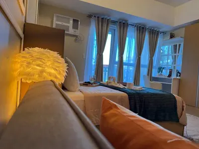 a living room with two beds and a couch at Cozy Studio Near Venice Mall Netflix WIFI in Manila