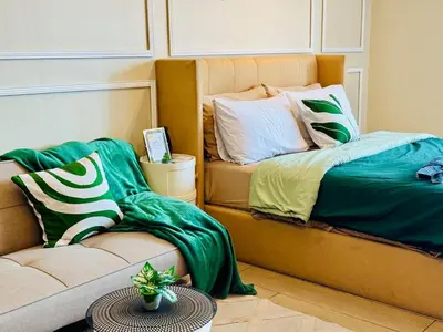 a room with a bed and a couch and a table at Cozy Studio Near Venice Mall Netflix WIFI in Manila
