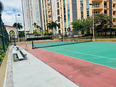 a tennis court in a city with buildings at Cozy Studio Near Venice Mall Netflix WIFI in Manila