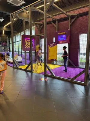 a group of children playing in a batting cage at Cozy Studio Near Venice Mall Netflix WIFI in Manila