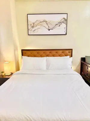 a bedroom with a large bed with white sheets at Santis Place at Eighty One Newport Blvd Across NAIA Terminal 3 in Manila