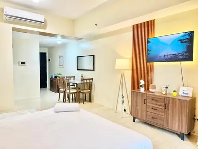 a bedroom with a bed and a dining room at Santis Place at Eighty One Newport Blvd Across NAIA Terminal 3 in Manila