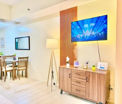 a living room with a table and a tv on the wall at Santis Place at Eighty One Newport Blvd Across NAIA Terminal 3 in Manila