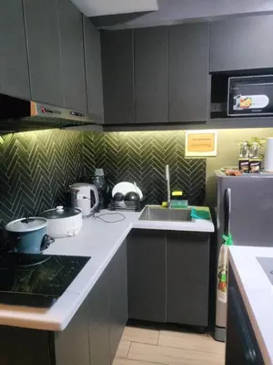 a kitchen with a sink and a refrigerator at Fully Furnished Condo Near BGC in Manila