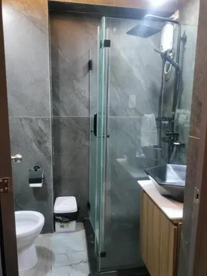 a bathroom with a shower and a toilet and a sink at Fully Furnished Condo Near BGC in Manila