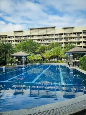 a large swimming pool in front of a large building at Mid-rise staycation in parañaque in Manila